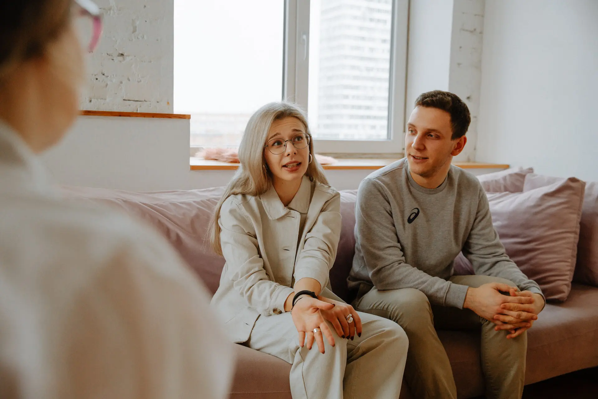 Woman sitting next to man on couch in meeting